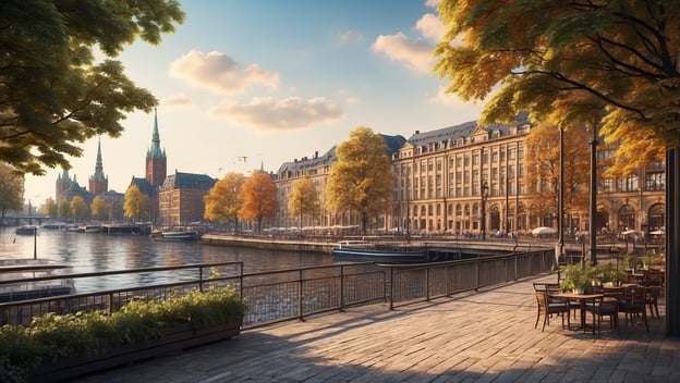 Hamburgs Uferpromenade mit historischen Gebäuden, buntem Herbstlaub und Blick auf das Wasser. Entspanntes Ambiente mit Tischen.