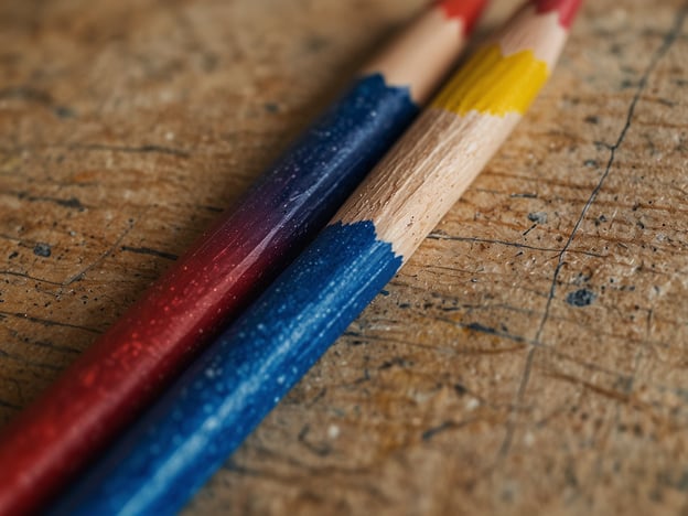Auf dem Bild sind zwei Buntstifte zu sehen, die auf einer Holzoberfläche liegen. Einer der Stifte ist rot, während der andere blau ist. Beide Stifte haben einen farbigen Abschluss, wobei der rote Stift eine rote Spitze hat und der blaue Stift eine blaue. Die Holzoberfläche zeigt verschiedene Strukturen und Unebenheiten.Flexibilität kann in der Kunst und beim Zeichnen sehr wichtig sein. Manchmal ist es nötig, neue Techniken auszuprobieren oder verschiedene Farben zu kombinieren, um das gewünschte Ergebnis zu erzielen.