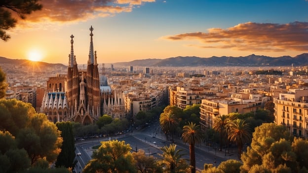 Blick auf Barcelona bei Sonnenuntergang mit der Sagrada Família im Vordergrund und den Bergen im Hintergrund.